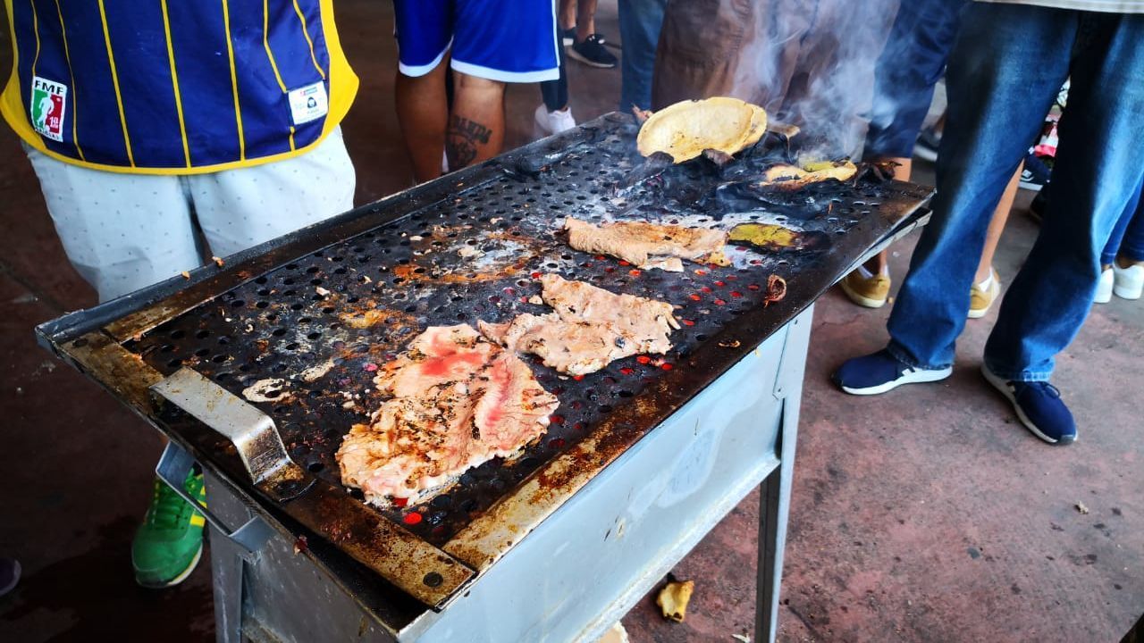 Con un anafre, fanáticos de Pumas hacen su carne asada en el Olímpico