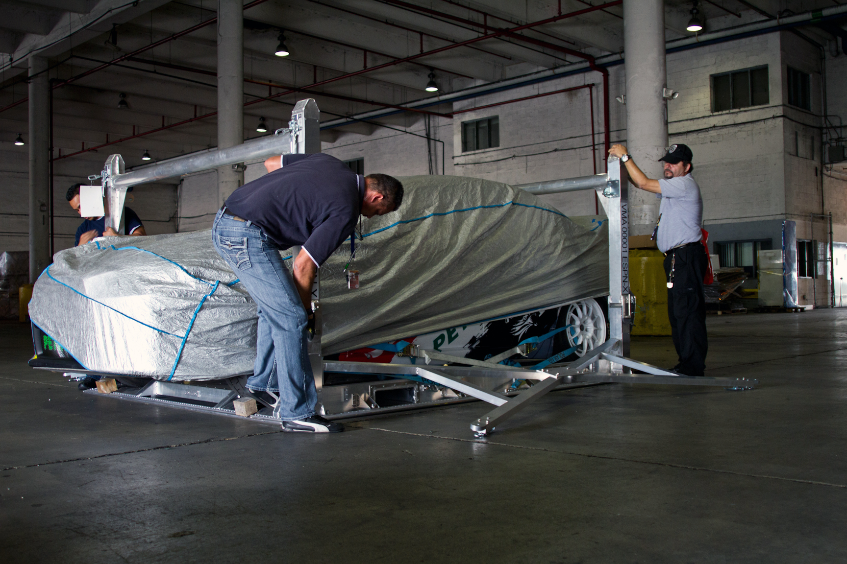 The crew finishes up the assembly of the bottom rack, preparing to stack the X Games official pace car on top.