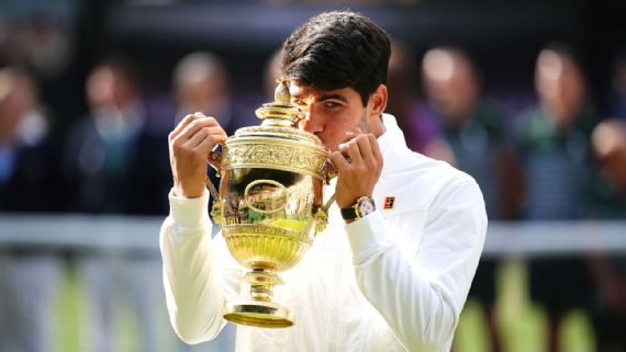 Carlos Alcaraz hoisting his Wimbledon trophy