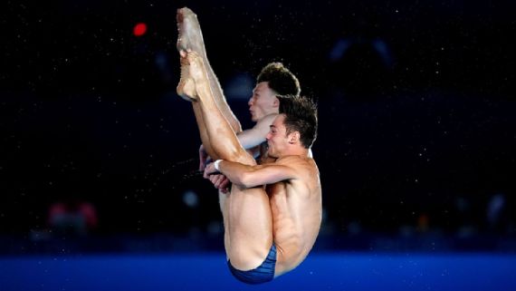 Tom Daley and Noah Williams stand on the podium, holding ‌their silver​ medals.