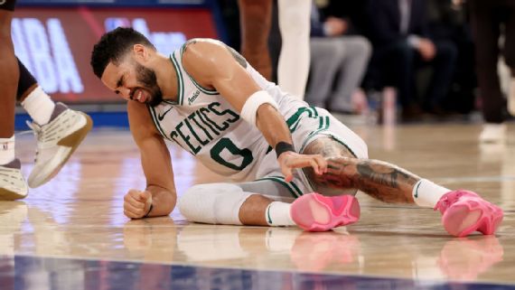 Jayson Tatum grimaces in pain after suffering an ankle injury against the Knicks.