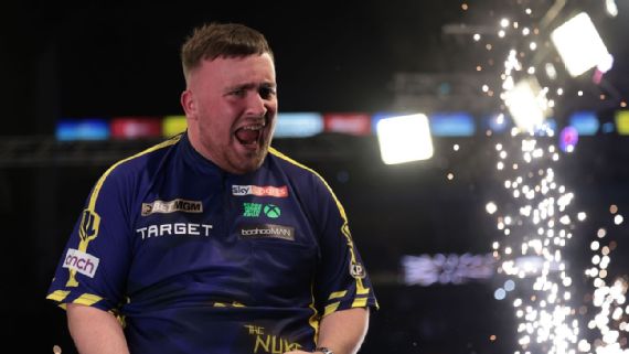 Luke littler holding the ⁣2025 Darts‍ world championship trophy.