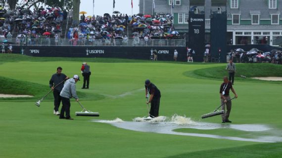 Groundskeepers removing water from the 18th hole at Oakmont
