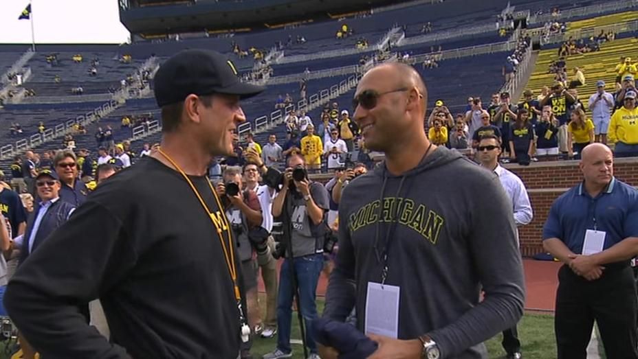 Former Yankees shortstop Derek Jeter, left, shakes hands with Michigan head  coach Jim Harbaugh, right, before an NCAA college football game against BYU  in Ann Arbor, Mich., Saturday, Sept. 26, 2015. Jeter