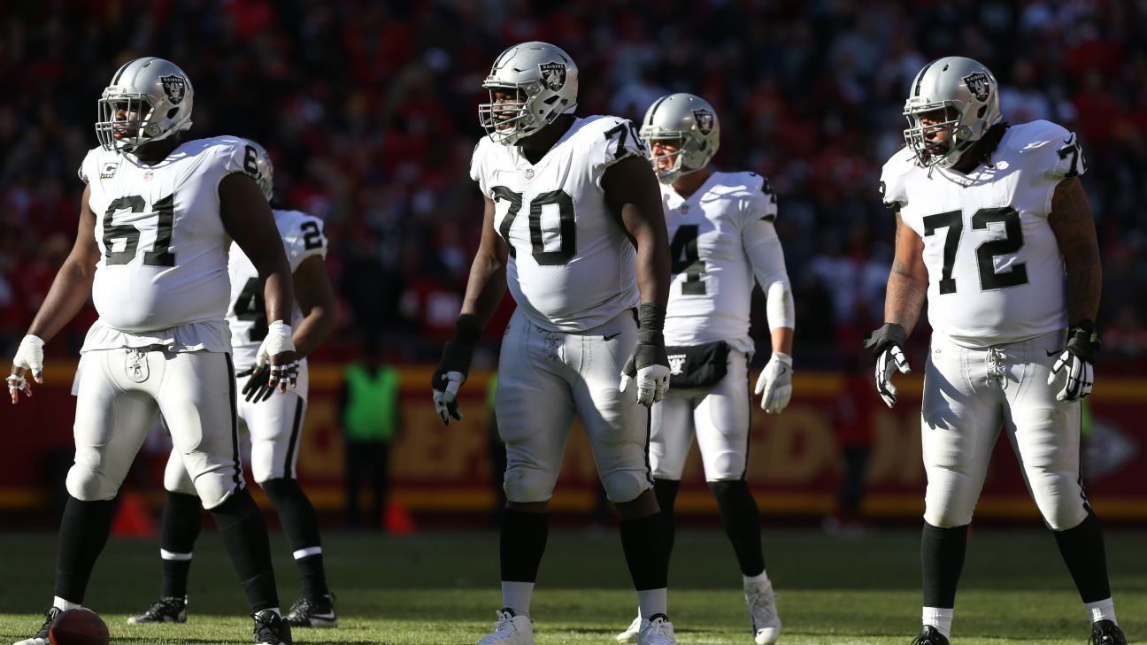 Oakland Raiders head coach Jon Gruden talks with center Rodney Hudson (61)  and quarterback Derek Carr, left rear, during the second half of an NFL  football game against the Miami Dolphins, Sunday, …