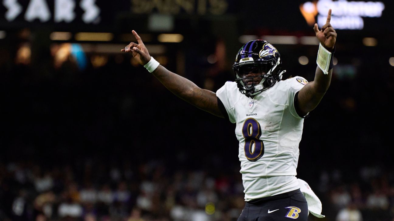 Baltimore Ravens quarterback Lamar Jackson (8) takes to the field with a  member of the military as part of Salute to Service before an NFL football  game against the Carolina Panthers, Sunday