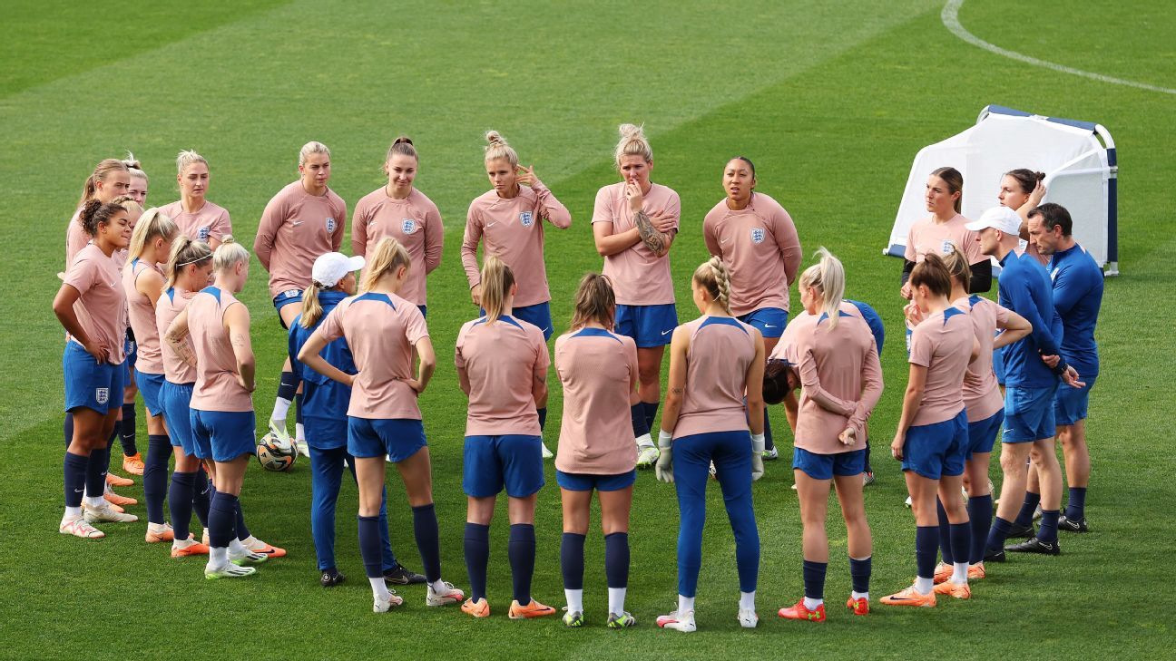 England cricket players look on during a training session, two